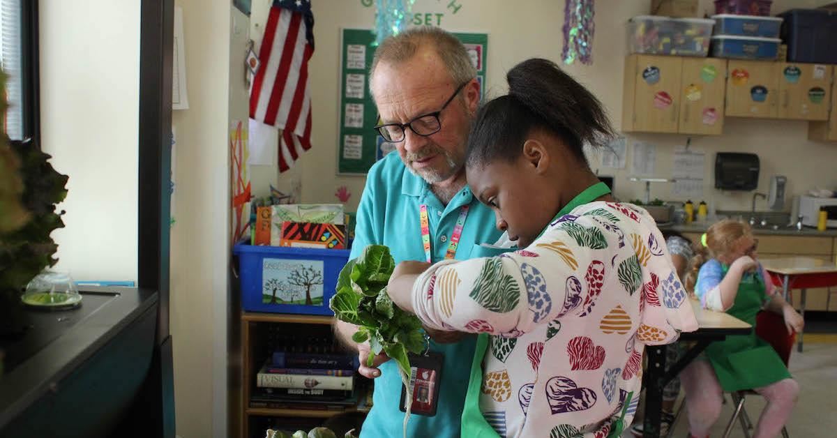 Student working with teacher on gardening